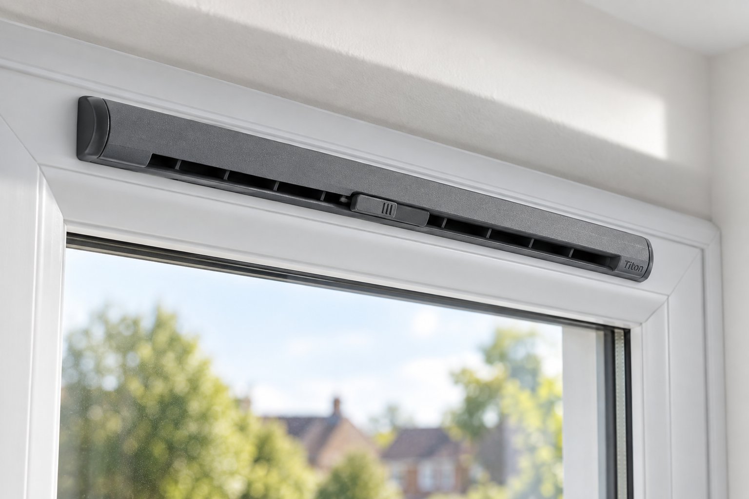 a trickle vent cover fitted to the top of a modern window frame with the slider partially open