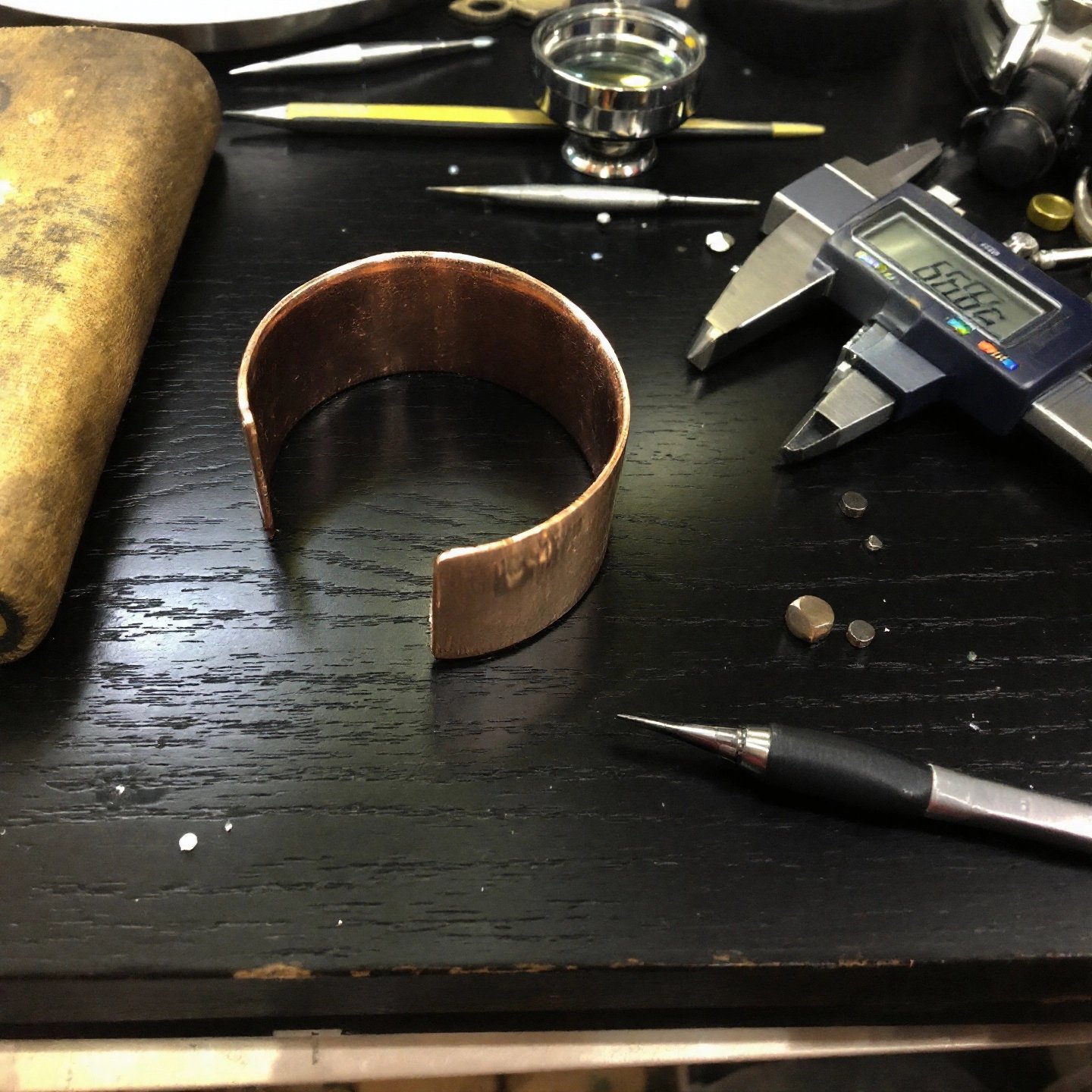 custom copper cuff bracelet being crafted with precision tools