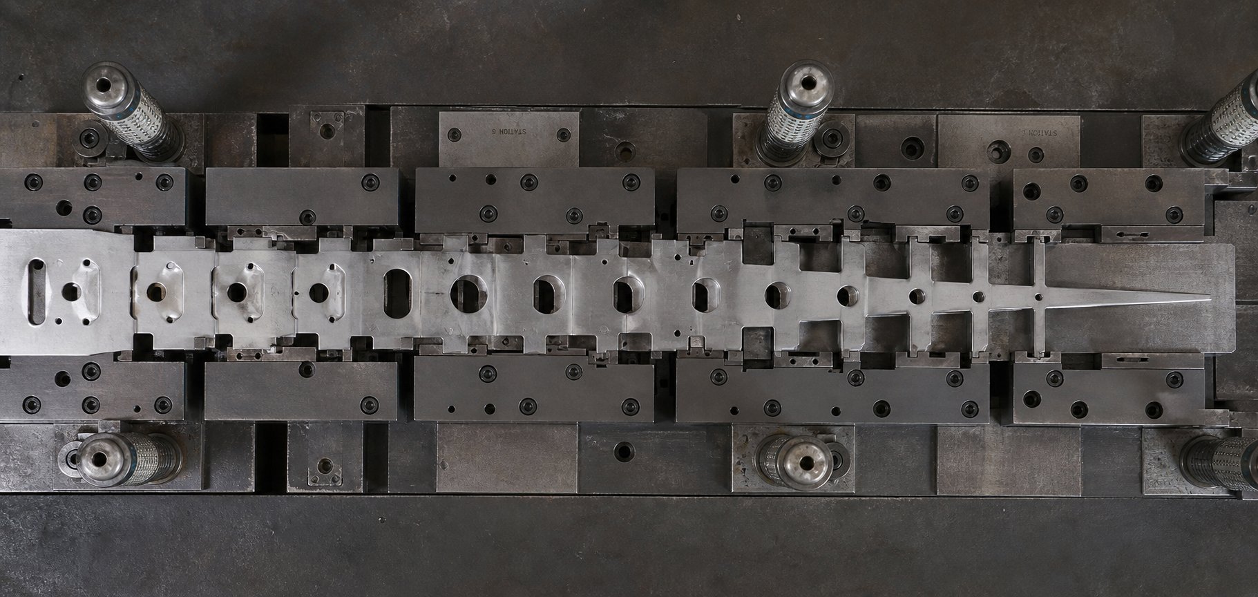 carrier strip showing cumulative cross section changes from multiple bypass notch stations in a progressive die