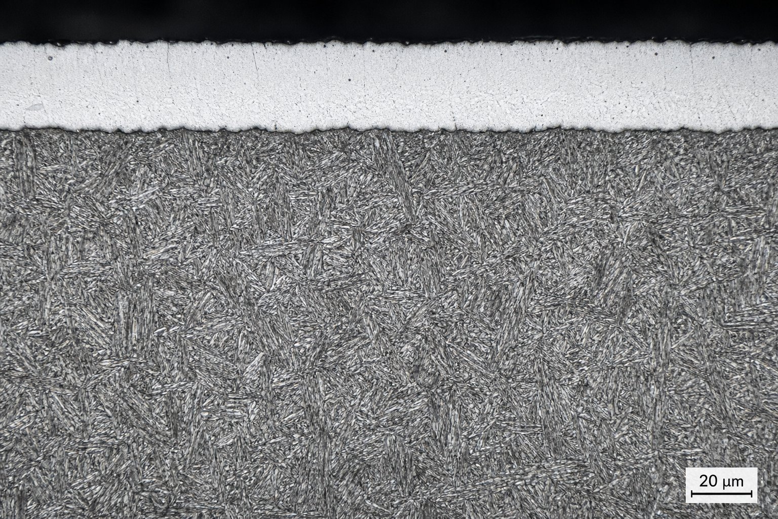 metallographic view of a nitrided steel surface revealing the white compound layer structure