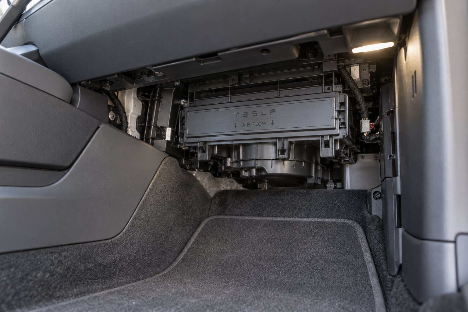 passenger side footwell view showing the cabin air filter housing location behind the lower dash panel
