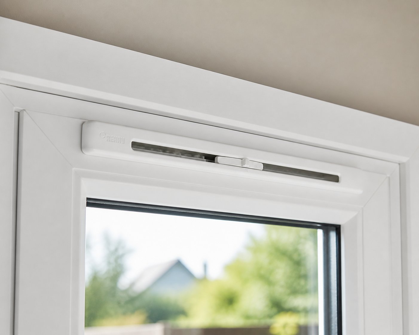 a trickle vent fitted to the head of a upvc window frame showing the internal canopy and adjustable slider