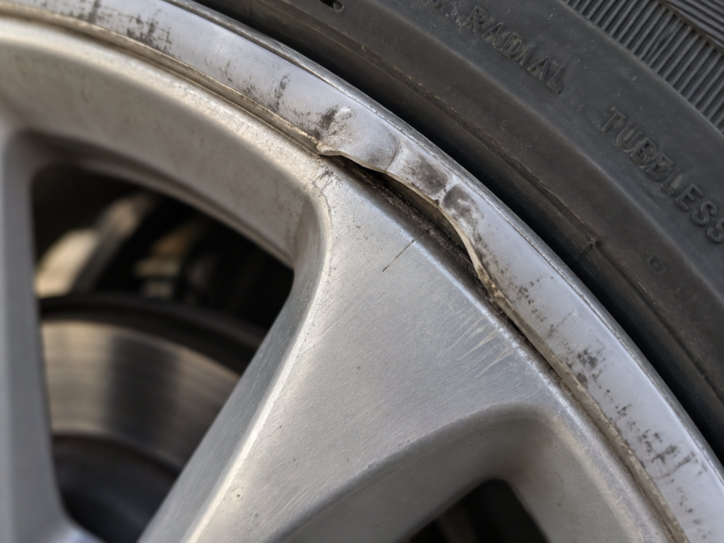 a worn rim protector strip lifting from the wheel edge signals adhesive failure and the need for replacement